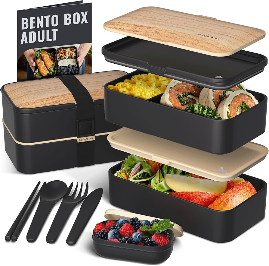 Overhead view of a filled bento box with teriyaki chicken, rice, edamame and fresh fruit in separate compartments